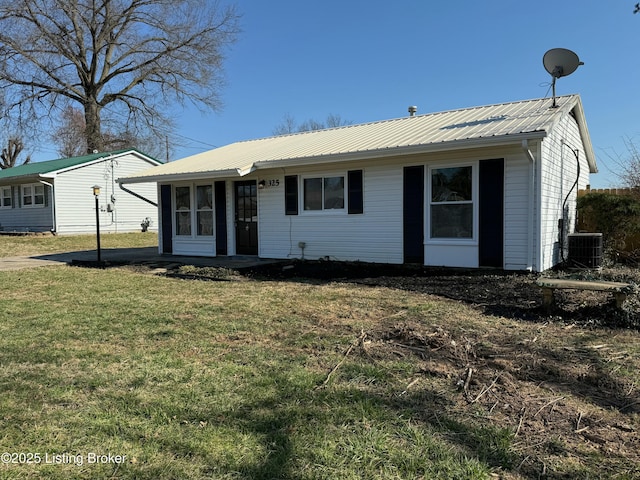 ranch-style house with a front yard, cooling unit, and metal roof