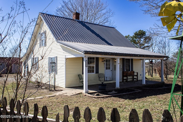 view of front of home with metal roof and a chimney