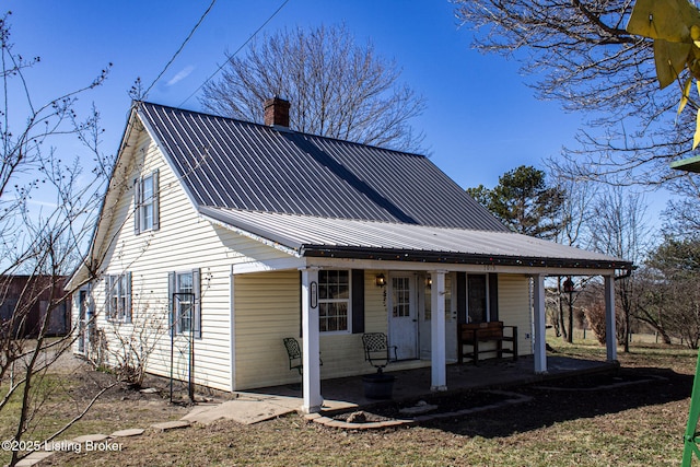 view of front facade with metal roof and a chimney