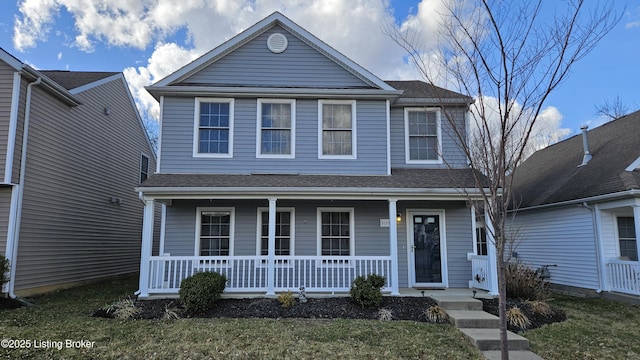 traditional-style home featuring a porch and roof with shingles