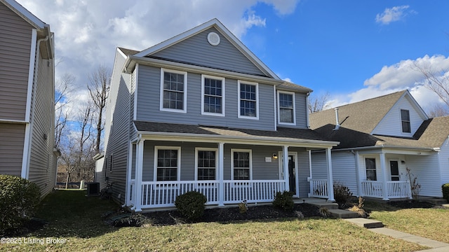 traditional-style house featuring a porch, a front lawn, central AC unit, and a shingled roof