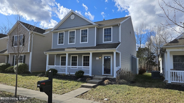 traditional home featuring covered porch and a front lawn