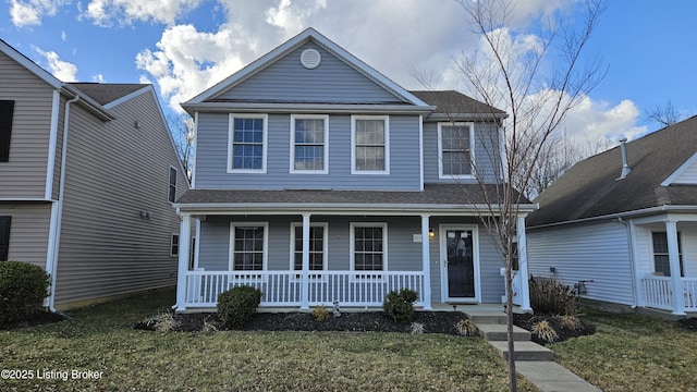 traditional home featuring a porch, a front yard, and a shingled roof