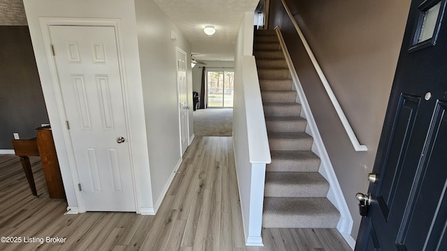 stairway featuring baseboards and wood finished floors