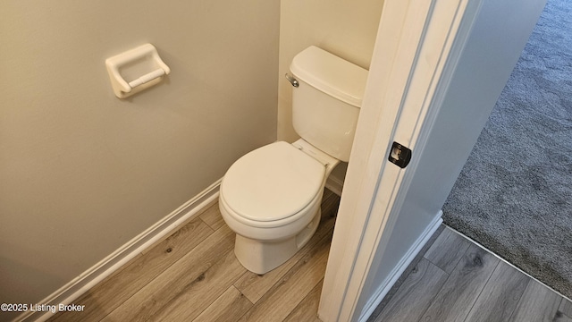 bathroom featuring wood finished floors, toilet, and baseboards