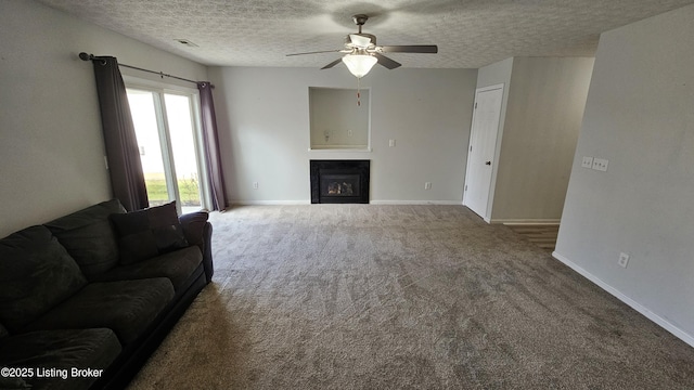 unfurnished living room featuring a glass covered fireplace, visible vents, a textured ceiling, and baseboards