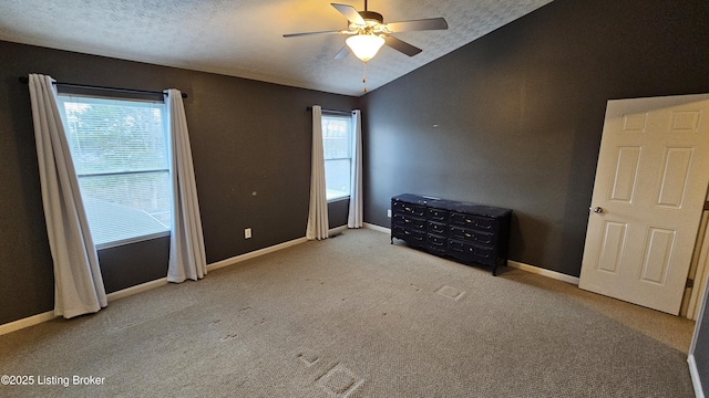 unfurnished bedroom with multiple windows, baseboards, and vaulted ceiling