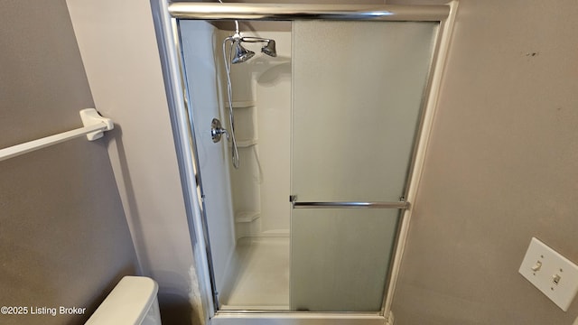 bathroom with a stall shower and toilet