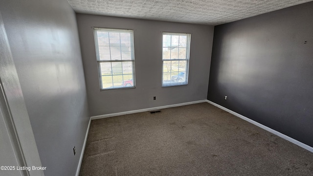 carpeted spare room with visible vents, baseboards, and a textured ceiling