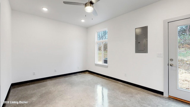 spare room with recessed lighting, a ceiling fan, baseboards, electric panel, and finished concrete floors