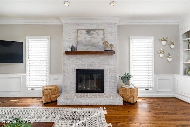 living area with a healthy amount of sunlight, crown molding, and wood finished floors