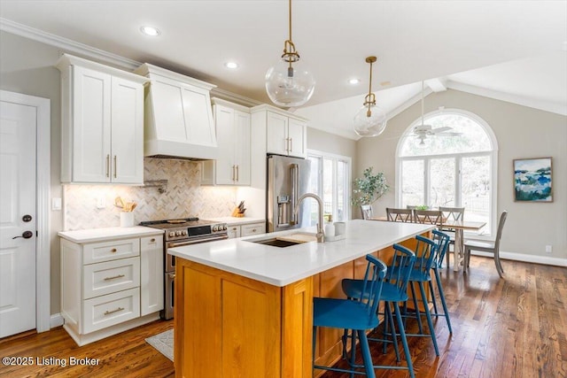 kitchen with stainless steel appliances, backsplash, lofted ceiling with beams, a sink, and premium range hood