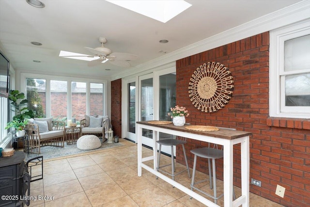 sunroom / solarium featuring a skylight and ceiling fan