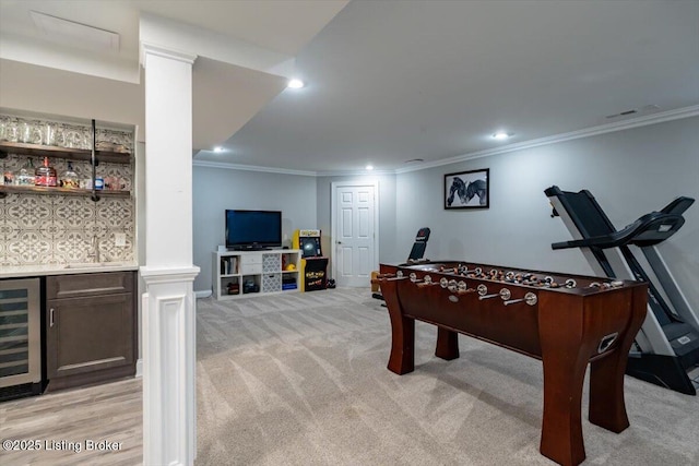 playroom featuring a dry bar, light colored carpet, wine cooler, crown molding, and recessed lighting