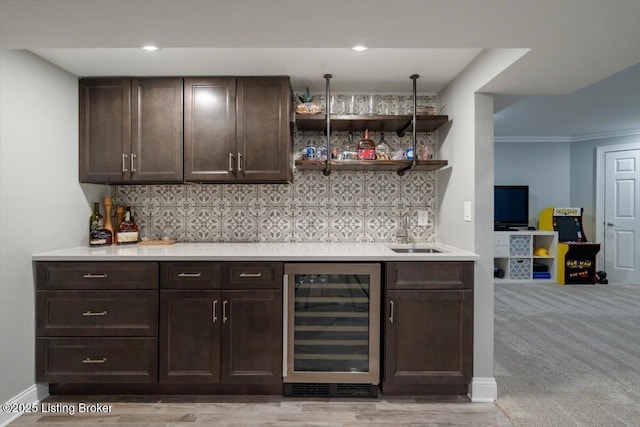 bar with a bar, wine cooler, backsplash, and a sink