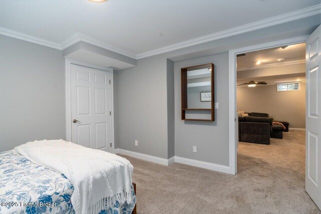 carpeted bedroom featuring crown molding and baseboards