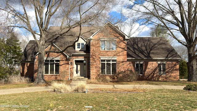 view of front of house with brick siding and a front lawn