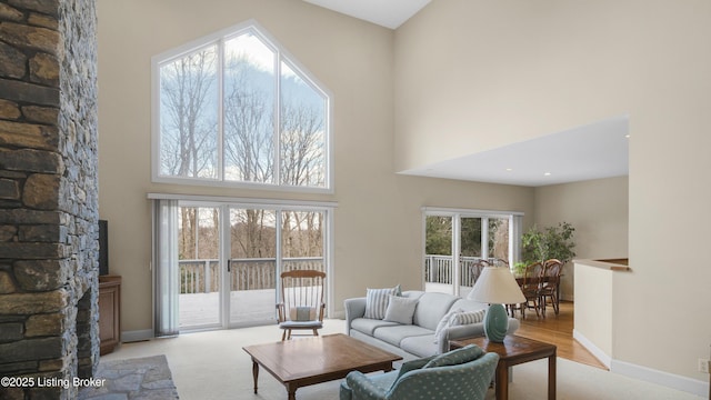 carpeted living room with a high ceiling and baseboards