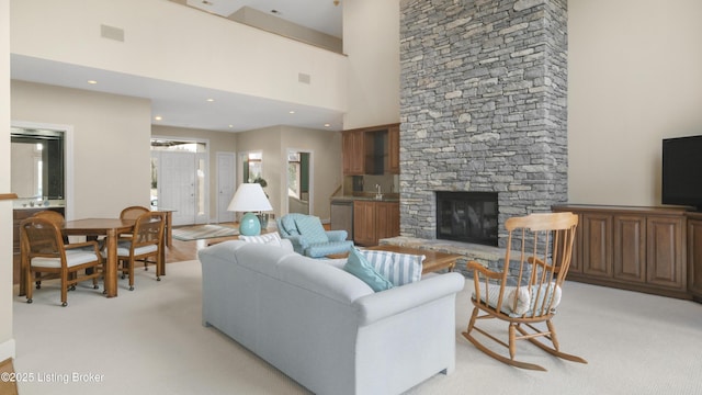 living room with visible vents, light colored carpet, a high ceiling, a fireplace, and recessed lighting