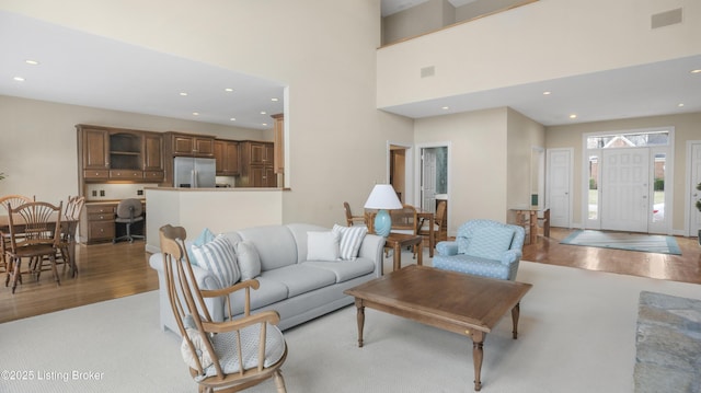 living room with light wood-style floors, recessed lighting, and visible vents