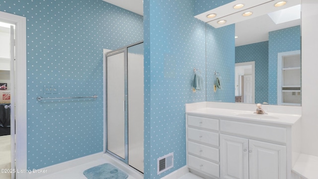 bathroom with a stall shower, a skylight, visible vents, and wallpapered walls