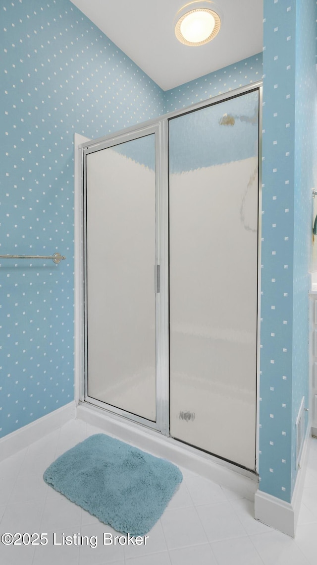 full bathroom featuring a shower stall, baseboards, tile patterned floors, and wallpapered walls