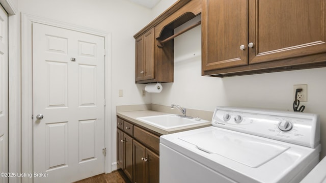 laundry area with a sink, washer / dryer, and cabinet space