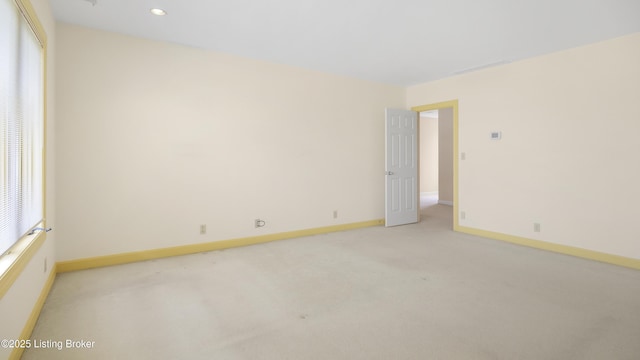 unfurnished room with light carpet and baseboards