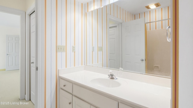 bathroom featuring wallpapered walls and vanity