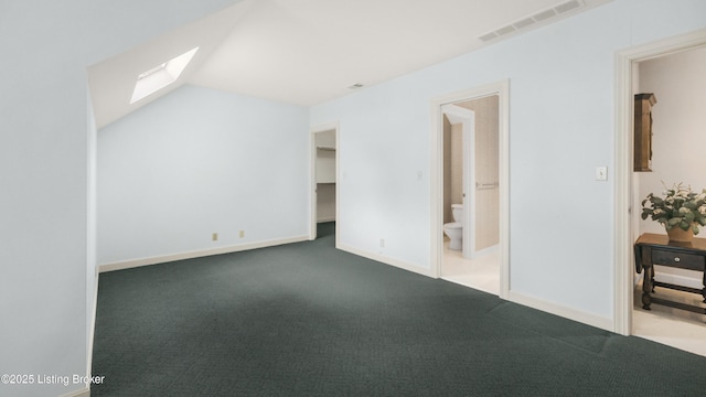 additional living space featuring lofted ceiling with skylight, baseboards, visible vents, and carpet flooring