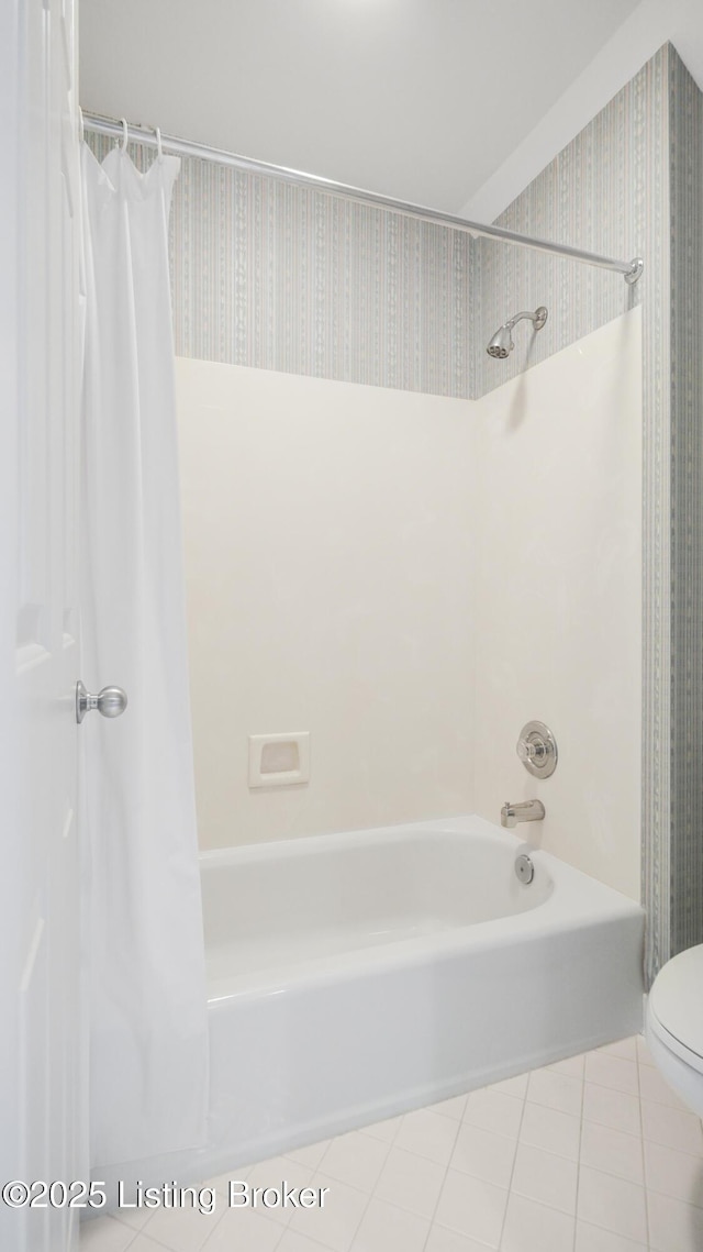 bathroom with tile patterned flooring, shower / tub combo with curtain, and toilet