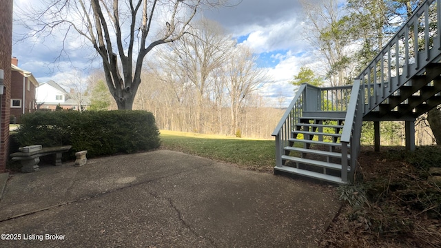 view of yard with a patio area and stairs