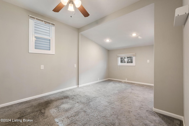 carpeted spare room featuring ceiling fan and baseboards