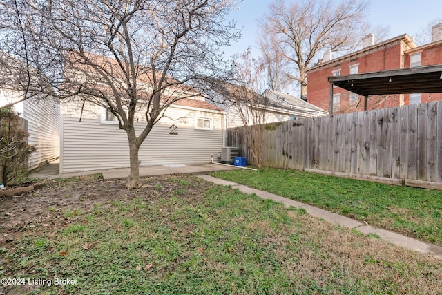 view of yard with central air condition unit and fence