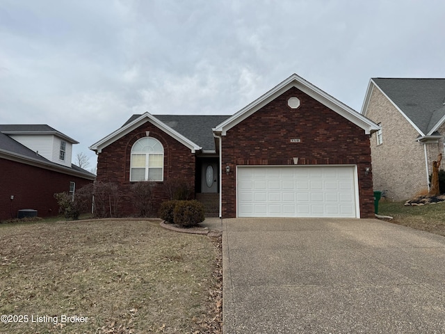 single story home with driveway, brick siding, and an attached garage