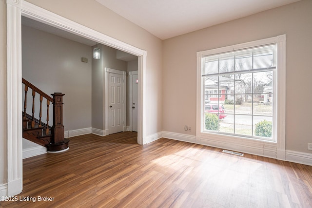 entryway featuring stairway, baseboards, visible vents, and wood finished floors