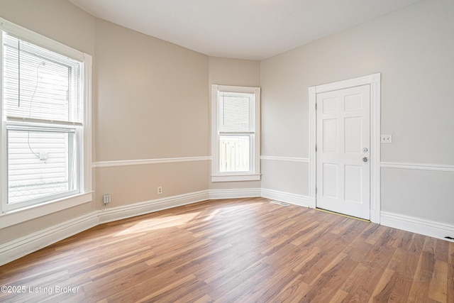 empty room featuring baseboards and light wood finished floors