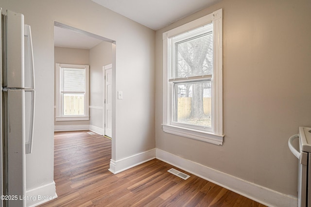 interior space featuring baseboards, visible vents, and wood finished floors