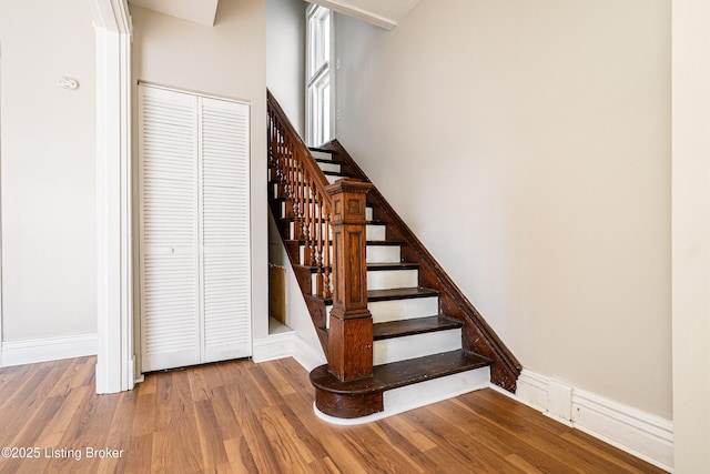 stairs with wood finished floors and baseboards