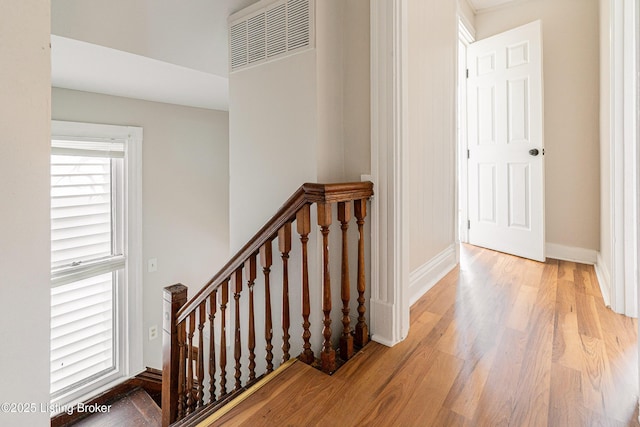 staircase with baseboards and wood finished floors