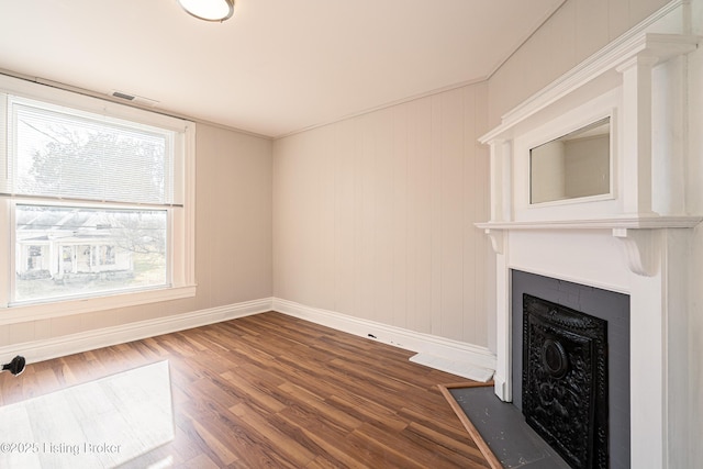 unfurnished living room featuring baseboards, a fireplace with flush hearth, visible vents, and dark wood-type flooring