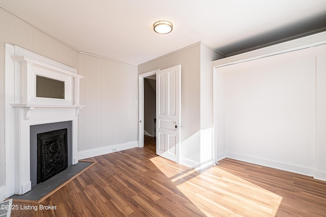 unfurnished living room with a fireplace, wood finished floors, and baseboards