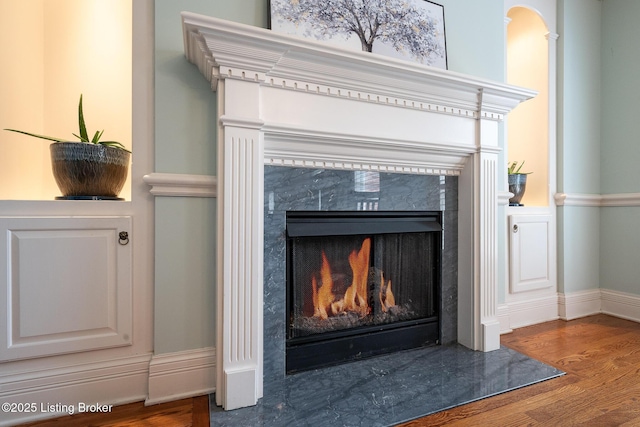 room details featuring wood finished floors, a high end fireplace, and baseboards