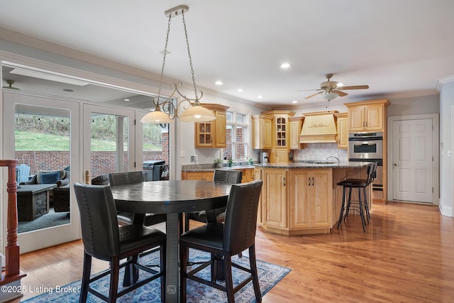 dining room featuring light wood finished floors, ornamental molding, a ceiling fan, and recessed lighting