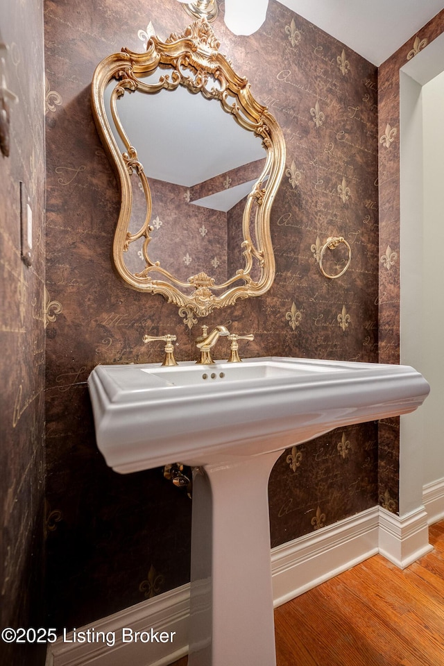 bathroom with baseboards and wood finished floors