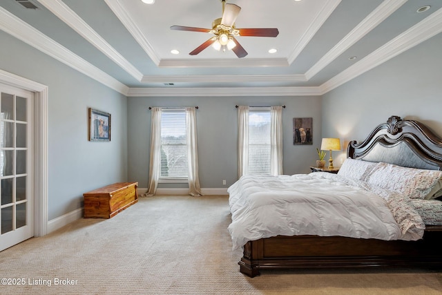 carpeted bedroom featuring a raised ceiling, crown molding, and baseboards