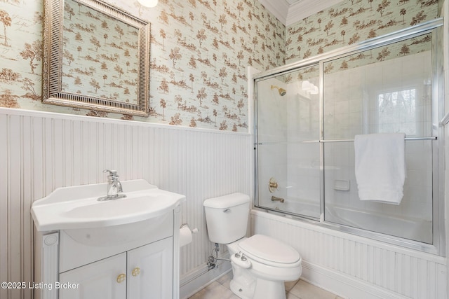 full bath with a wainscoted wall, toilet, enclosed tub / shower combo, vanity, and wallpapered walls