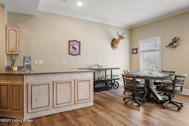 dining room with dark wood-type flooring, ornamental molding, and baseboards