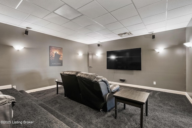 carpeted cinema room featuring a paneled ceiling, visible vents, and baseboards