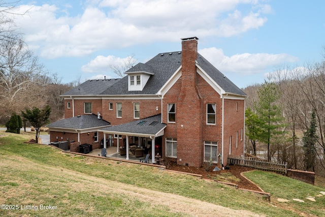 rear view of property featuring central AC unit, brick siding, a yard, a chimney, and a patio area